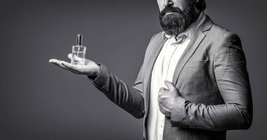 Elinde parfüm şişesi tutan bir erkek. Erkek parfümü, parfüm. Parfüm, parfüm şişesi, parfüm, kozmetik, parfüm şişesi, erkek parfümü. Siyah ve beyaz.