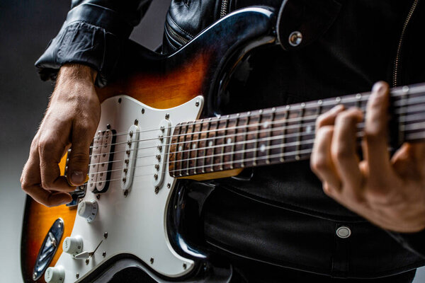 Close up hand playing electric guitar. Musician playing guitar, live music. Man playing guitar. Musical instrument. Electric guitar. Repetition of rock music band.