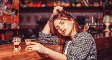 Alkol ve alkol bağımlılığı konsepti. Elinde bir bardak viski ya da rom tutan sarhoş kadın. Depresyondaki kadın. Genç ve güzel bir kadın alkol içiyor..