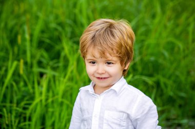Doğada bir çocuk. Mutlu çocuk. Yeşil çimlerin üzerinde izole edilmiş komik bir erkek bebek. Gülümseyen çocuk. Neşeli neşeli çocuk. Mutlu çocuklar..