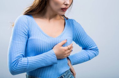 Kalp krizi geçiren bir kadın. Kalp krizi konsepti. Kalp ağrısı çeken ve göğsünü tutan bir kız. Sağlık ve tıbbi konsept. Göğüs ağrısı çeken bir kız. Göğüs ağrısı çeken bir kadın..