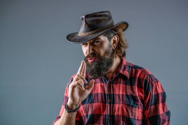 Batı, silahlar. Kovboy portresi. Maskeli Amerikalı haydut, şapkalı batılı adam. Şapkalı kovboy portresi. Kovboy şapkalı, silahlı bir adamın portresi. Bir kovboyun portresi.