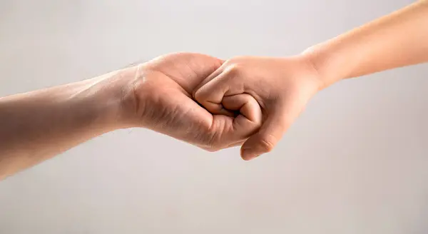 Male and child hands connected each other together and forever. Woman and kid hands connect with each other. Friendly handshake, friends greeting. Rescue, helping hand. Man help hands, protection.