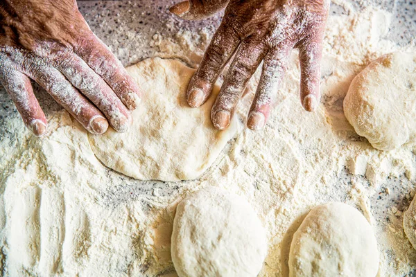 Baking at home. Homemade cakes dough in the womens hands. Process of making pies, hand. Hands pie dough. Cooks dough for baking, pieces of raw dough. Womans hands rolling doughs for pies.