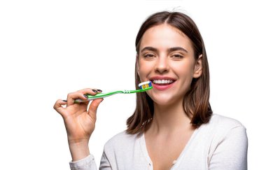 Diş fırçasıyla mükemmel ve sağlıklı dişleri kapat. Elinde diş fırçası tutan gülümseyen sevimli bir kadının portresi. Elinde diş fırçası tutan güzel dişleri olan gülümseyen bir kadın. Diş sağlığı geçmişi.