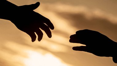 Uzanmış eller, kurtuluş, siluete yardım, konsept yardım. Kurtarma, el hareketlerine yardım etme. Gökyüzü arka planında iki el silueti, bağlantı veya yardım kavramı.