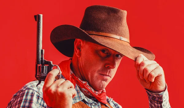 Man wearing cowboy hat, gun. West, guns. Portrait of a cowboy. American cowboy. Cowboy wearing hat.
