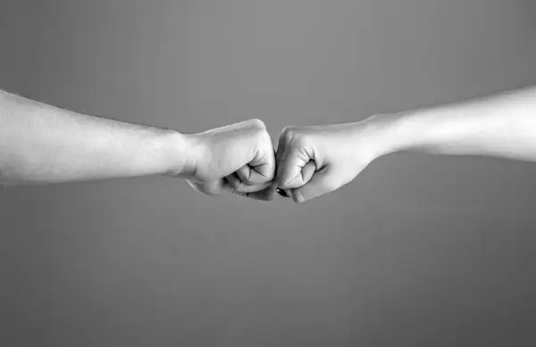 Fist Bump. Clash of two fists, vs. Gesture of giving respect or approval. Friends greeting. Teamwork and friendship. Partnership concept. Black and white.