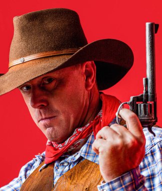 Kovboy şapkalı, silahlı bir adam. Batı, silahlar. Kovboy portresi. Amerikan kovboyu. Şapkalı bir kovboy. Batı hayatı. Kovboy şapkalı adam. Maskeli Amerikalı haydut, şapkalı batılı adam..