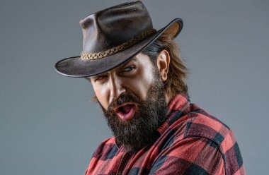 Şapkalı kovboy portresi. Kovboy şapkalı, silahlı bir adamın portresi. Kovboy portresi. Batı, silahlar. Kovboy portresi. Maskeli Amerikalı haydut, şapkalı batılı adam..