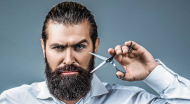 Berber makası. Klasik berber dükkanı. Berber makası, berber dükkanı. Sakallı, şık, profesyonel bir kuaförün portresi. Makas tutan adam. Berber makası, berber dükkanı..