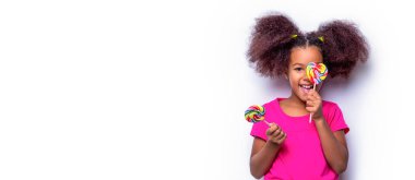Elinde gülümseyen küçük tatlı bir kız. Kız afro, lolipoplar. Gülümse küçük Amerikalı kız lolipop yiyor, elinde pembe renkli lolipop şekeri, şekerler.