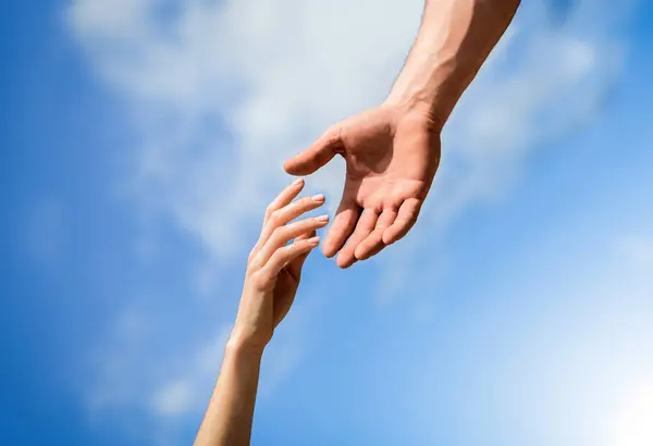 Giving a helping hand. Hands of man and woman reaching to each other, support. Rescue, helping gesture or hands. Lending a helping hand. Solidarity, compassion, and charity, rescue.