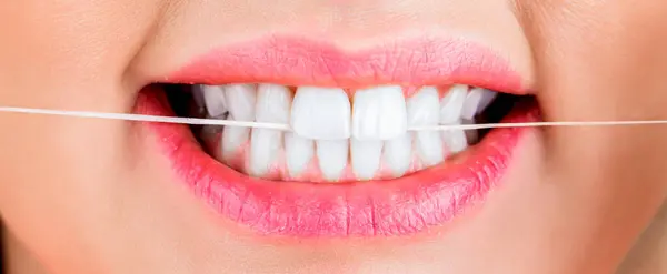 Dental floss. Oral hygiene and health care. Smiling women use dental floss white healthy teeth.