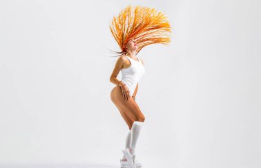 Kız örgüleri. Örgülü güzel bir genç kızın portresi. Saçında renkli kanekalon örgüsü olan güzel, şık bir kadın. Renkli turuncu saç örgüleri olan güzel bir kadın. Kuaför salonu konsepti.