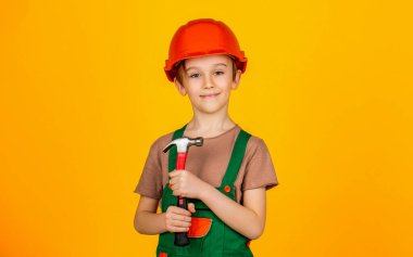 Çekiçli küçük müteahhit. Çocuk miğferi, başlık. Çekiç sesi. Küçük miğfer ve Hummer 'lı müteahhit. İşçi gibi giyinmiş bir çocuk. Miğfer takan küçük çocuk.