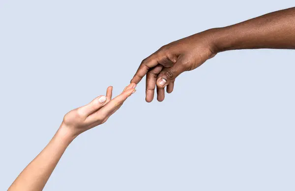 World unity and racial love and races. Hand skin colors touch two. Woman and African American man touching hands. White Caucasian female hands and black African American holding fingers together.