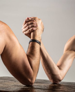 Zayıf elle bilek güreşi, stüdyoda güçlü bir kol. İki adamın elleri birbirine kenetlenmiş bilek güreşi, güçlü ve zayıf, eşit olmayan maç..