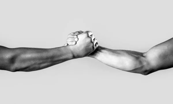 Two hands, helping arm of a friend, teamwork. Friendly handshake, friends greeting, teamwork, friendship. Close up help hand. Black and white.