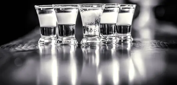 Set of alcoholic cocktails in shot glasses. Colorful shots at the club. Alcoholic drink in different colors. Black and white.