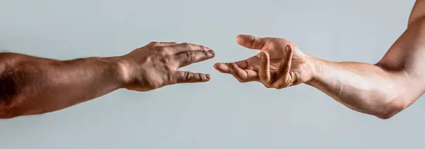 Hands reaching out to help or give. Two male hands reaching towards each other. Hands of man and woman reaching to each other. Two hands, helping arm friend, teamwork. Helping hand concept, support.