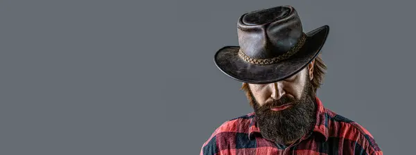 Cowboy Hat. Portrait of young man wearing cowboy hat. Cowboys in hat. Handsome bearded macho. Man unshaven cowboys.