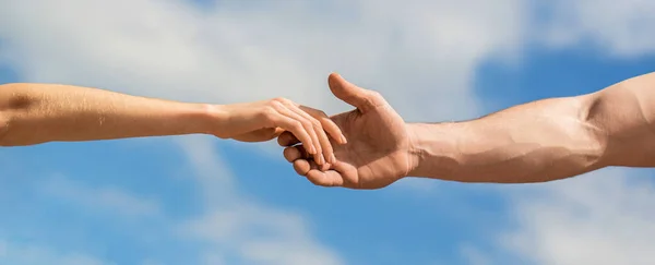Solidarity, compassion, and charity, rescue. Hands of man and woman reaching to each other, support. Giving a helping hand. Lending a helping hand.