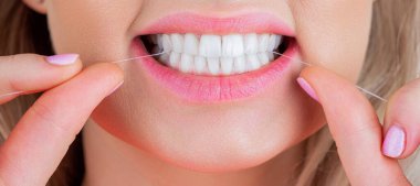 Diş ipi mi? Ağız temizliği ve sağlık hizmetleri. Gülümseyen kadınlar diş ipi kullanır. Sağlıklı dişler. Dişlerine bakıyorum. Sağlıklı diş kavramı. Diş ipliği..