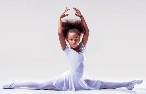 Flexible little african american girl ballerina. african girl ballet studio. Ballerina in dance class. Girl white tutu, leotard learning to dance. Child dancer exercising. Kids practice full split.