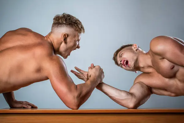 Man competitors arm wrestling. Men competitors try to win victory or revenge. Men measuring forces, arms. Hand wrestling, compete. Two men arm wrestling. Rivalry, closeup of male arm wrestling.