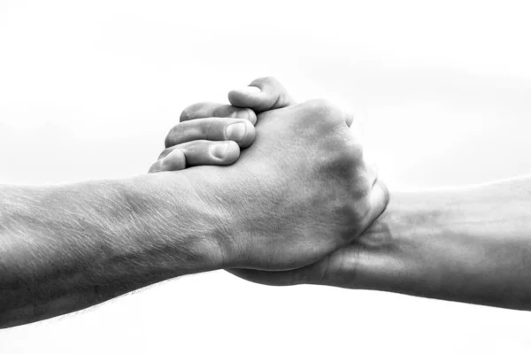 Helping hand concept and international day of peace, support. Closeup. Helping hand outstretched, isolated arm, salvation. Friendly handshake. Two hands, shaking hands. Black and white.