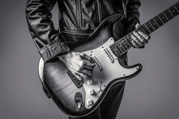 Hands of a musician playing the electric guitar. Electric guitar, guitarist, musician rock. Guitar acoustic. Play the guitar. Live music. Music festival. Instrument on stage, band. Black and white.