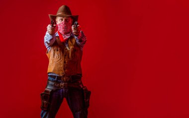 Silahlı bir kovboy, kovboy şapkalı silahlı bir adam. Şapkalı Batılı adam. Amerikalı çiftçi. Kovboy şapkalı, silahlı bir adam. Batı, silahlar. Bir kovboyun portresi.