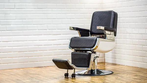 Barber chairs in white interior. Theme for hairdressers, style barber, hairdresser for men, barber shop. Stylish barber chair. Barbershop theme. Professional hairstylist in barbershop interior.