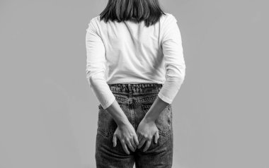 Hemorrhoids. Anus. Pain. Woman holds his hands to the ass feeling pain. Woman hand holding her bottom because having abdominal pain and Hemorrhoids. Black and white.