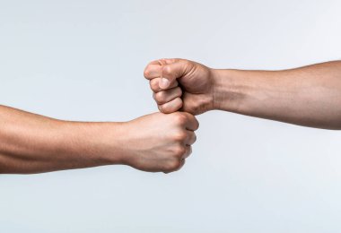 Yumruk tokuştur. İki yumruğun çarpışması, karşı karşıya. Saygı gösterme ya da onaylama hareketi. Dostlar selamlıyor. Takım çalışması ve arkadaşlık. Ortaklık kavramı. Erkekler yumruk tokuşturuyor.