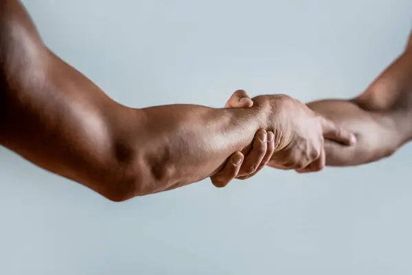 Rescue, helping gesture or hands. Strong hold. Close-up. Two hands, helping hand of a friend. Handshake, arms, friendship. Friendly handshake, friends greeting, teamwork friendship