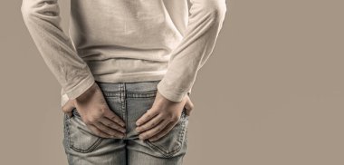 Child boy standing with holding her butt having hemorrhoids or rhypophobia, feel painful, sick child suffer from constipation or diarrhea.