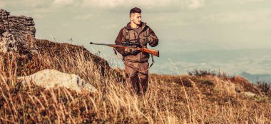 Kamuflaj elbiseli erkek avcı av tüfeğiyle avlanmaya hazır. Silahlı bir erkek. Avcı tüfekli bir avcı, avlanmak için avlanma biçimi..