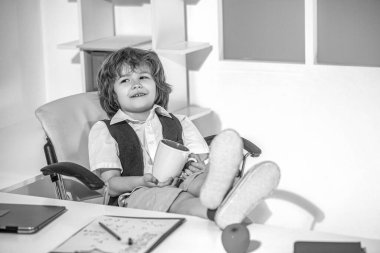 Ofiste gülümseyen küçük patron. Çocuklar için komik bir evde eğitim. Ofisteki küçük patron, iş adamı. Siyah ve beyaz.
