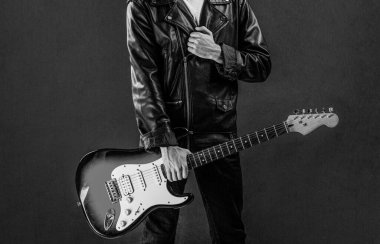 Gitar çalan adam yakın plan. Elektro gitar çalan bir müzisyenin elleri. Elektro gitar, gitarist, müzisyen rock. Rock grubu iş başında. Siyah ve beyaz.