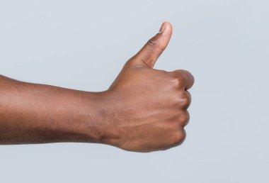 Jest gibi. Yakından çekilen el başparmaklarını gösteriyor. Erkek elleri baş parmağını kaldırıyor. Destek desteği. Afrika erkek eli baş parmağını gösteriyor. Afro-amerikan elleri.