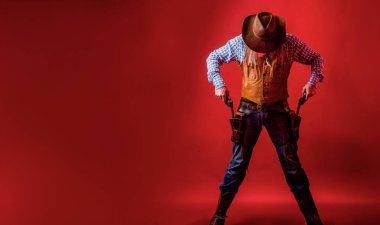 Silahlı bir kovboy, kovboy şapkalı silahlı bir adam. Şapkalı Batılı adam. Kovboy şapkalı, silahlı bir adam. Batı, silahlar. Bir kovboyun portresi.