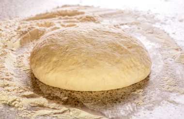 Yakın çekim mayalanmış hamur, ev yapımı. Makro seçici odaklı ham hamur dokusu arkaplanı. Yuvarlanmış hamur dokusu. Hamur işlerinin arka planı. Pizza veya ekmek pişirmek için taze çiğ hamur..