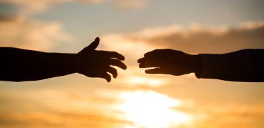 Adam gün batımında dışarıdaki adama yardım ediyor, yakın plan. Yardım ve destek kavramı. Gün batımındaki gökyüzü arkaplanına yakın çekim yardım ediyor. Kurtarma Yardımı.