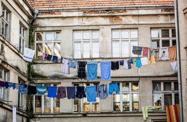 Giysiler bilgi arasında ipte kurutulur. Fakir bölge. Eski bir evin dışında çamaşır yıkadım. Fakir semt, fakir semtin evleri. Elbiseler çamaşır ipinde kurumaya bırakılmış..