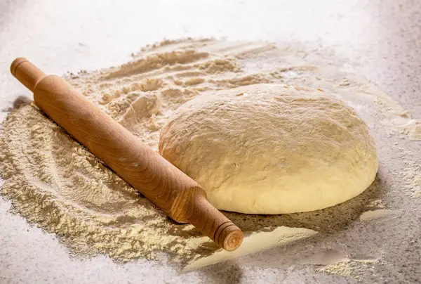 Pizza ve merdane için Hamur. Mutfak masasında ev yapımı pizza. Taze çiğ hamur ve rulo. Pizza ya da ekmek pişirmek için çiğ hamur.