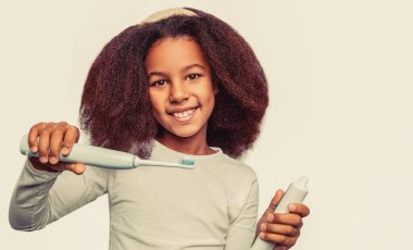 Sağlıklı dişler, diş macunu. Küçük kız, diş fırçası. Küçük tatlı Afrikalı Amerikalı kız dişlerini fırçalıyor..