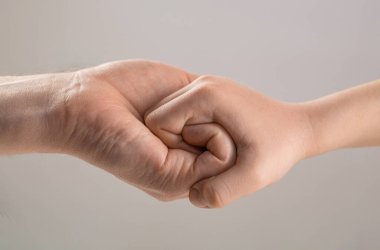 Erkek ve çocuk elleri sonsuza dek birbirlerine bağlandılar. Dostça tokalaşma, dostça selamlaşma. Kurtarma, yardım eli. Adam yardım eder, koruma sağlar. Kadın ve çocuk elleri birbirine bağlanır..