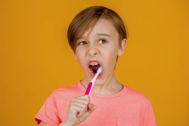 Erkek diş fırçası beyaz diş macunu. Sağlık hizmeti, diş hijyeni. Çocuk diş fırçalarını gösteriyor. Küçük çocuk diş temizliyor..